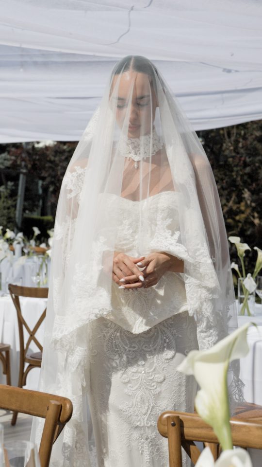 Bride standing beneath her veil