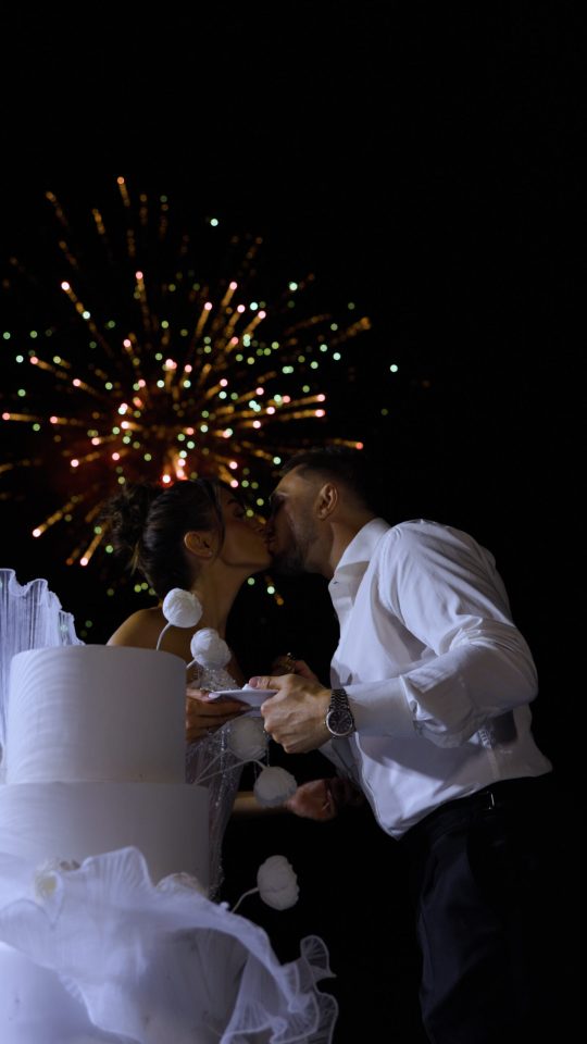 Bride and groom celebrating with their wedding cake and fireworks